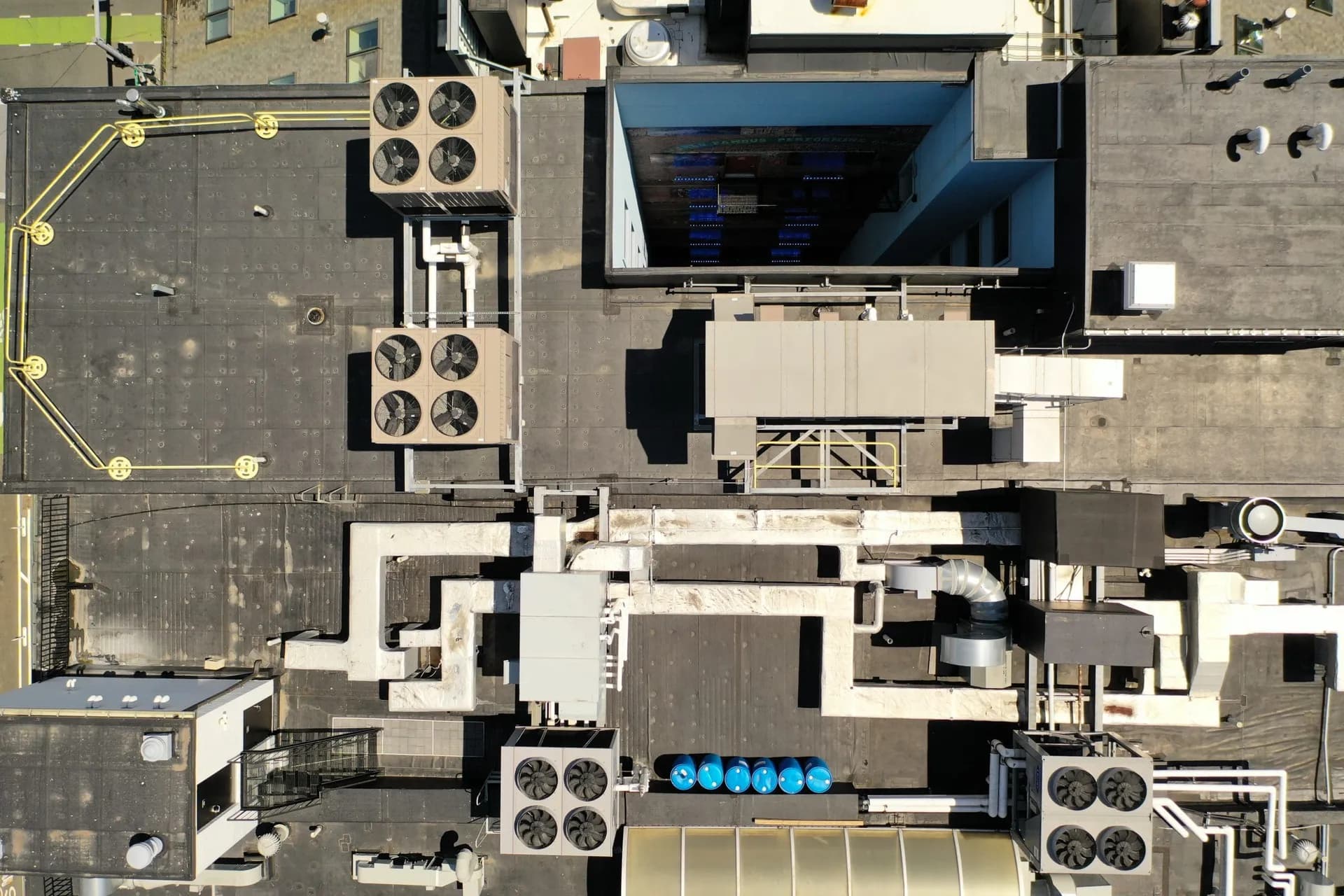 Top-down view of a finished flat commercial roof with rooftop HVAC units and curbs.